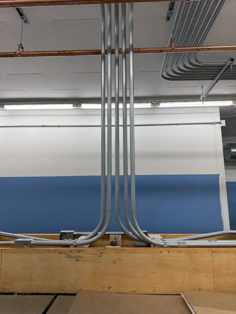 Close-up of newly installed electrical conduits with precise bends, part of a commercial project by Pro Circuit Electric in Peoria, IL.