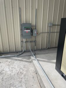 Electrical conduits and junction boxes installed on a building exterior by Camo Construction & Electric in Lake Charles, LA.
