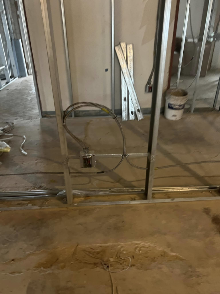 Electrical conduit and junction boxes being installed within metal framing during construction by My A Plus Electric SA in San Antonio, TX