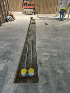 Electrical conduits and junction boxes being installed in a concrete floor by Nelson Electric in Brooklyn Park, MN