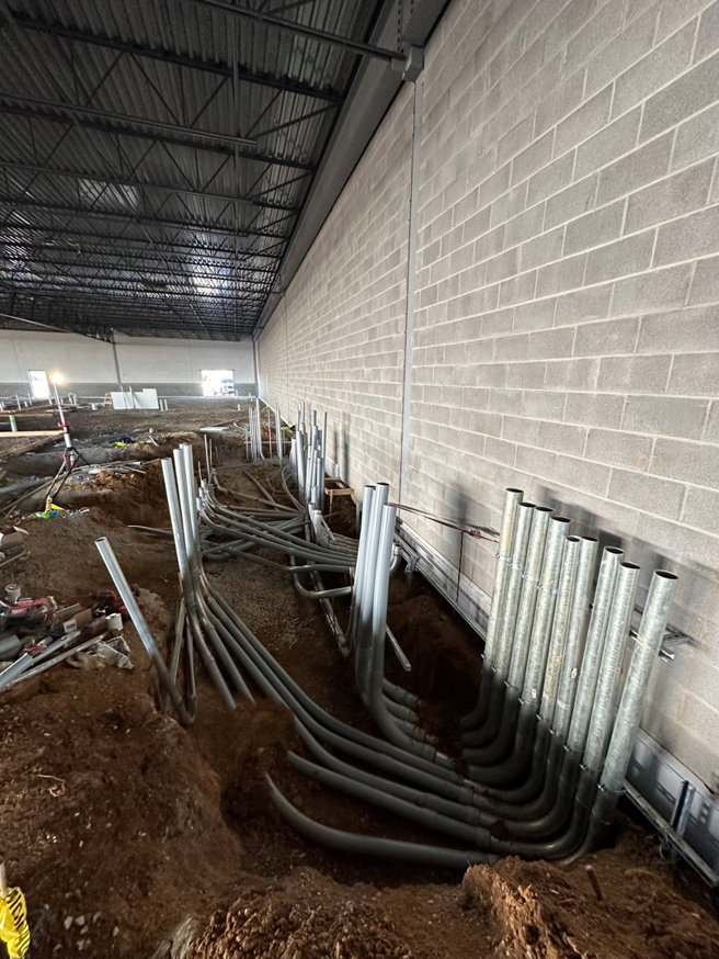 Electrical conduits being installed in the ground at a construction site by Rebco Electric in Lebanon, OH.