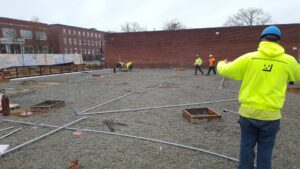 Electricians laying out electrical conduits on a construction site, performed by Icon West Corporation Electrical Contractors in Springfield, MA.