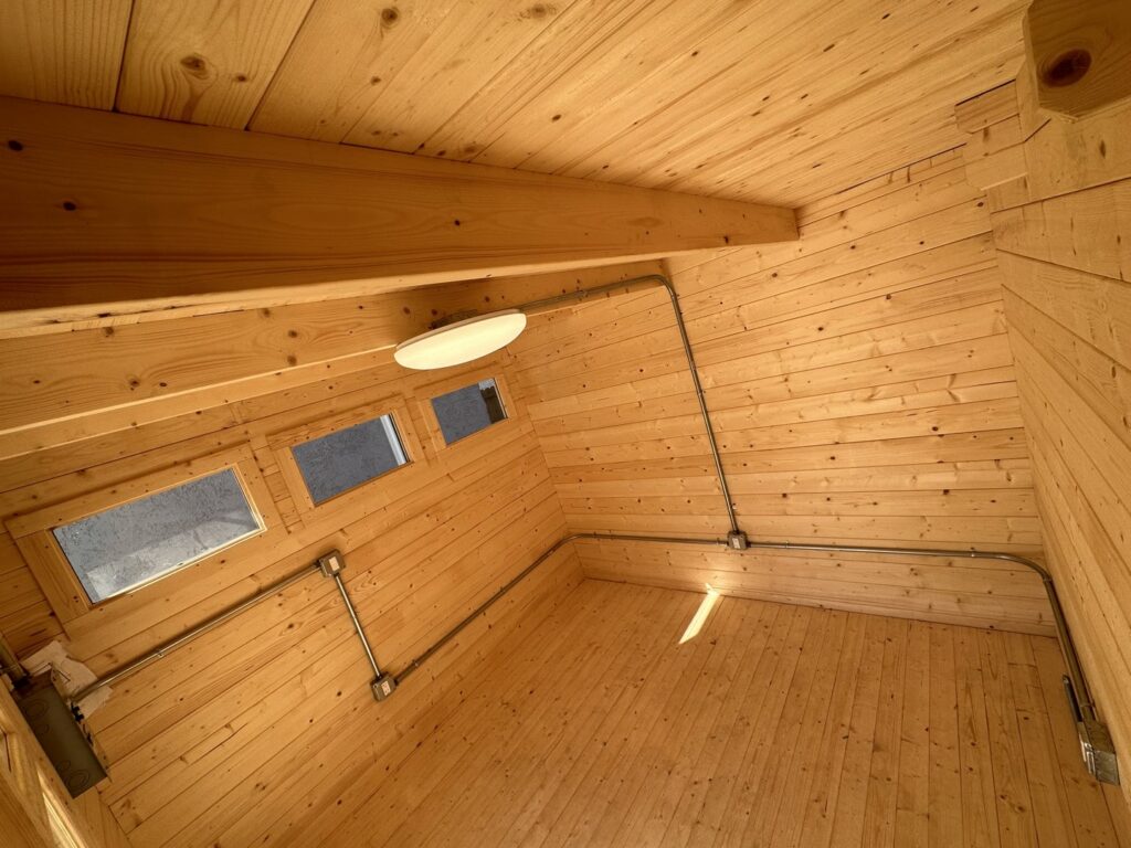 Electrical conduit and lighting fixture installation inside a wooden structure by Positive Electricians in Van Nuys, CA.