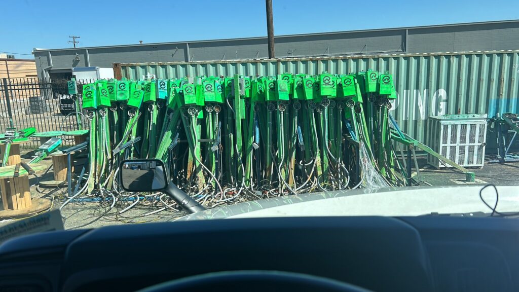 A large stack of green electrical conduit and wiring materials stored at Crest Electrical Solutions in Arlington, TX.