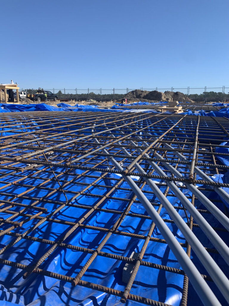 Electrical conduit laid out with rebar on a construction site, part of a project by Harbour Electric in Wilmington, NC.