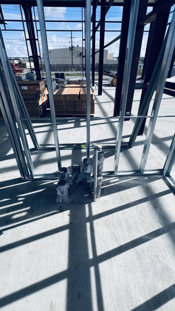 Electrical conduit rough-in emerging from concrete slab at a job site by Coast Electric Inc in Kenner, LA