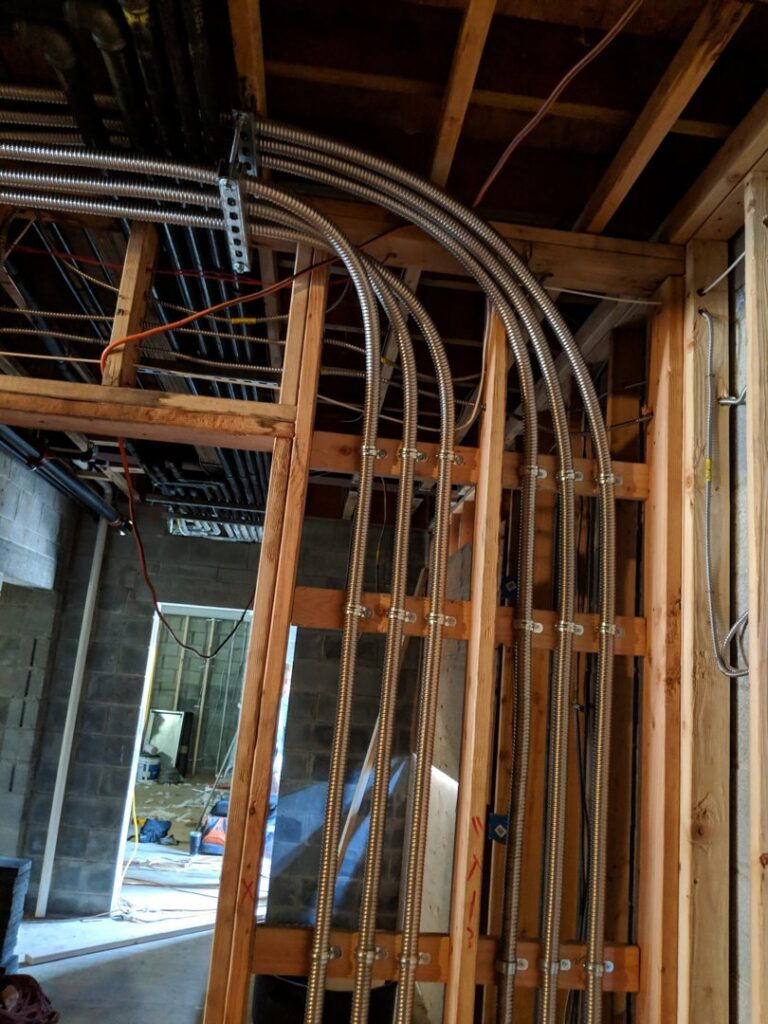 Electrical conduit rough-in installed within wall studs during a construction project by E & E Electric in Post Falls, ID.