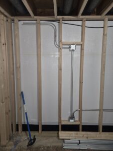 Electrical conduit and junction boxes installed within wall framing during construction by ILIC Electric in Chicago, IL.