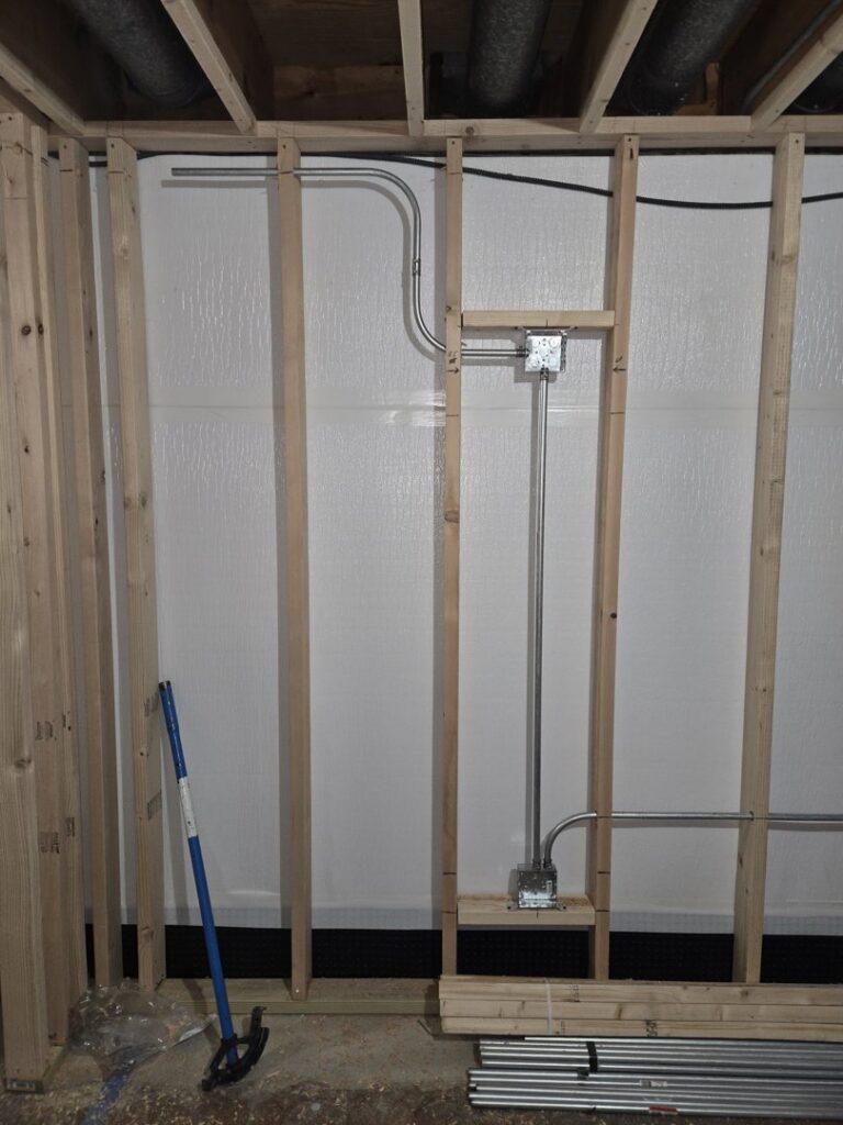 Electrical conduit and junction boxes installed within wall framing during construction by ILIC Electric in Chicago, IL.