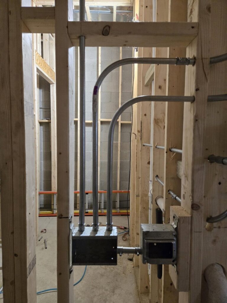 Electrical conduit and junction boxes installed in new construction framing by ILIC Electric in Chicago, IL.