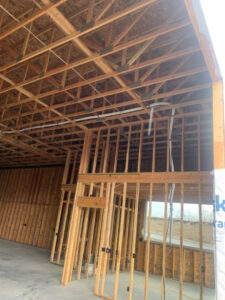 Electrical conduit and wiring running along the ceiling during rough-in in a building under construction by Interstate Electrical Contractors in Dalton Gardens, ID.