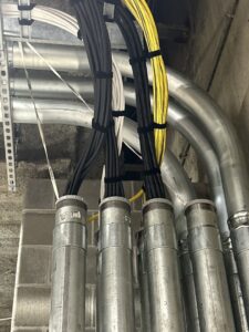 Close-up of electrical conduit and wiring installation with neatly bundled cables by Wired Inc. in Lincoln, NE.