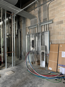 Electrical conduits and panels installed on a brick wall at a job site by Streff Electric, Inc. in Cedar Rapids, IA