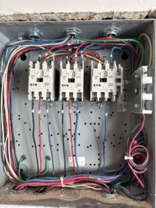 A close-up of an electrical control box with relays and intricate wiring by Tenax Electrical Company in Jacksonville, FL.