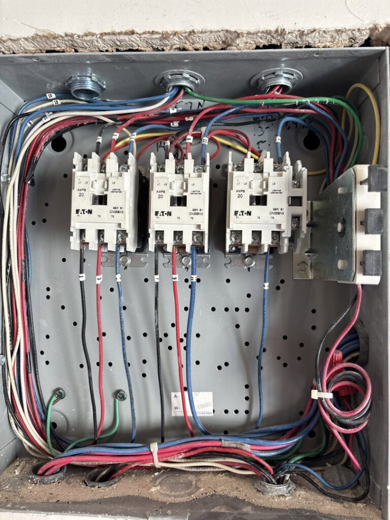 A close-up of an electrical control box with relays and intricate wiring by Tenax Electrical Company in Jacksonville, FL.