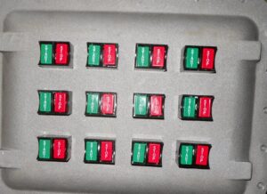An electrical control panel featuring multiple "Start" and "Stop" buttons for industrial machinery, provided by Basic Supply in Lafayette, LA.