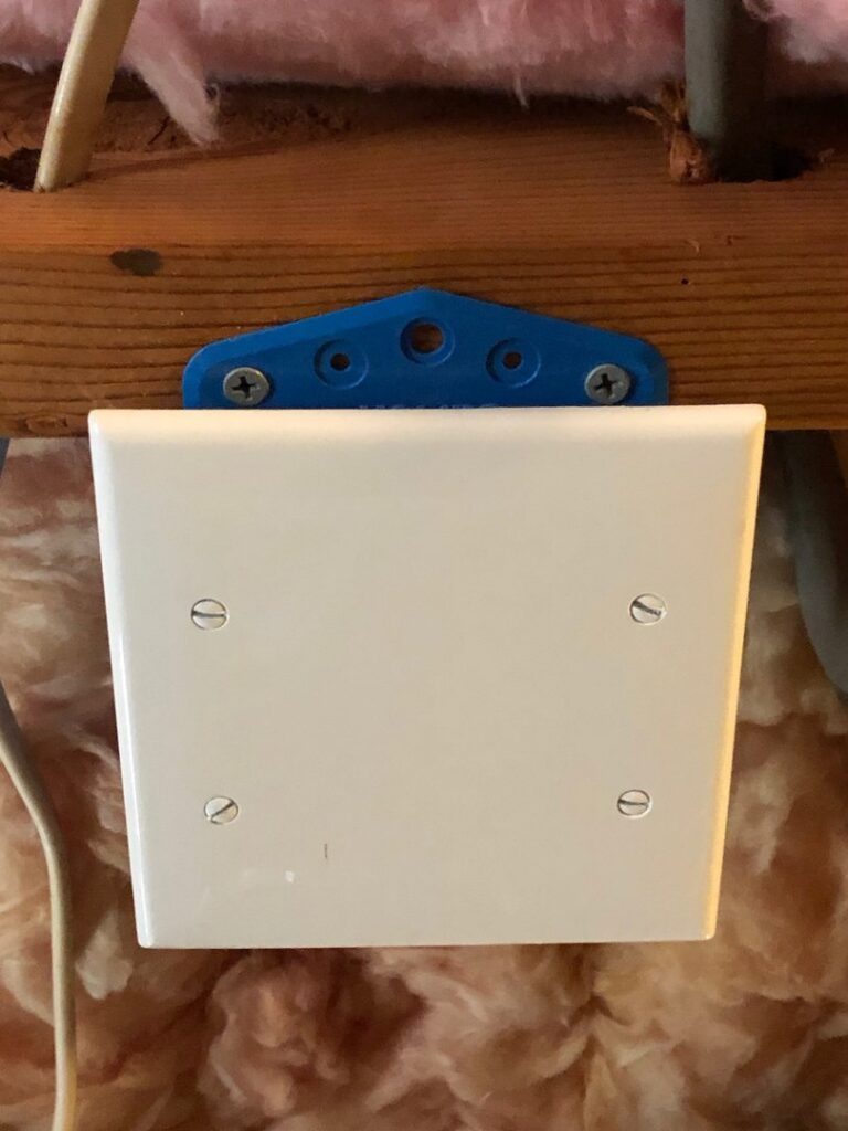 A newly installed electrical cover plate on a wooden beam, showcasing quality electrical work by Brooker Electric in Roswell, GA.