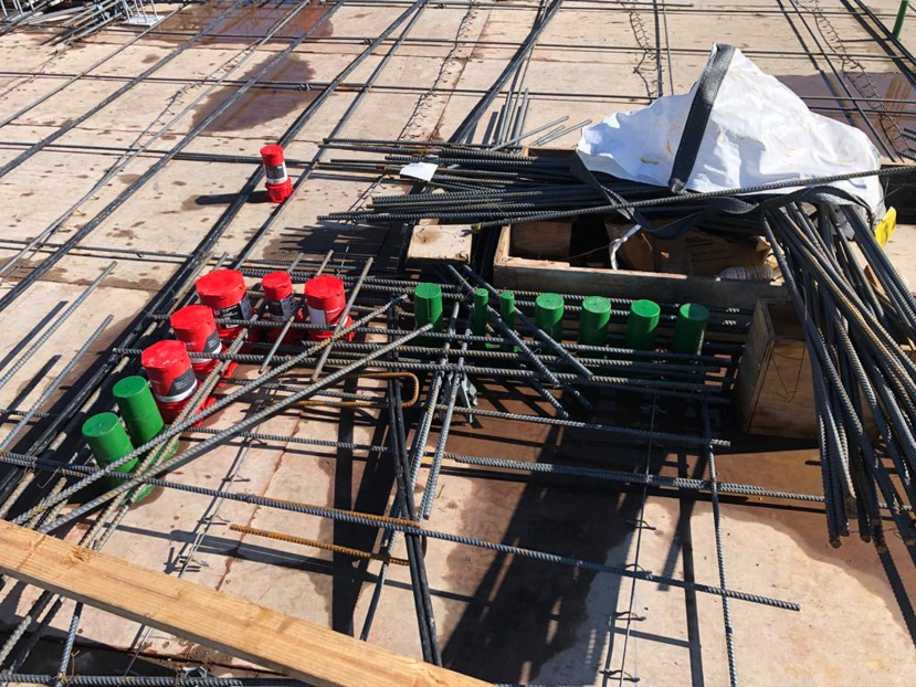Red and green electrical and data conduits installed with rebar on a construction site by MVL Electric, LLC in Atlanta, GA