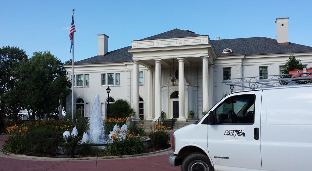 An Electrical Dimensions, Inc. service van with a ladder rack parked at a commercial job site in Verona, WI.