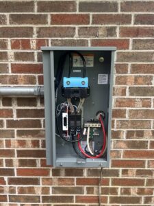 Internal wiring of an electrical disconnect box installed on a brick wall by Ark Electrical Service in Tomball, TX