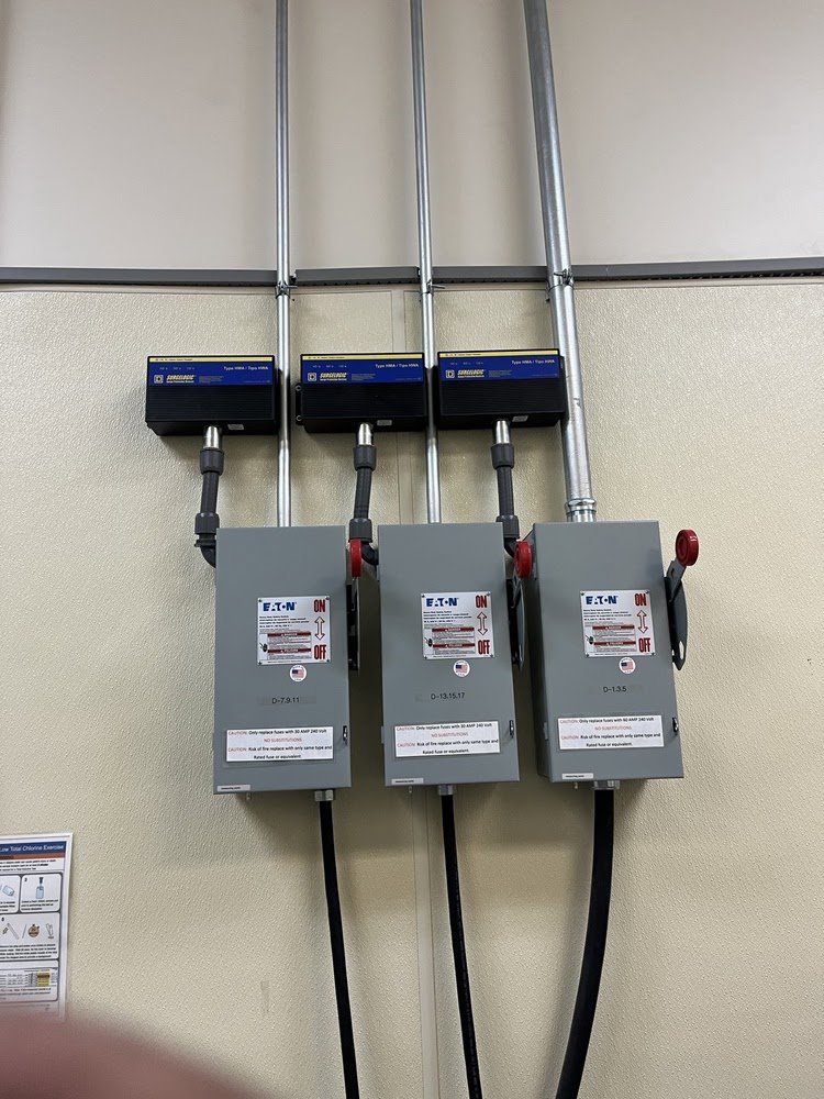 Three electrical disconnect boxes with conduit installed on a wall by Blevens Electric LLC in Bowling Green, KY