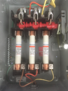 An open electrical fuse panel displaying multiple fuses and intricate wiring by Shines Electric in Orlando, FL.