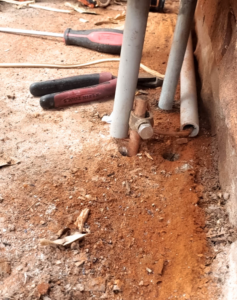 A close-up of an electrical grounding rod and conduits installed in the ground by Eon Electric in Orem, UT.