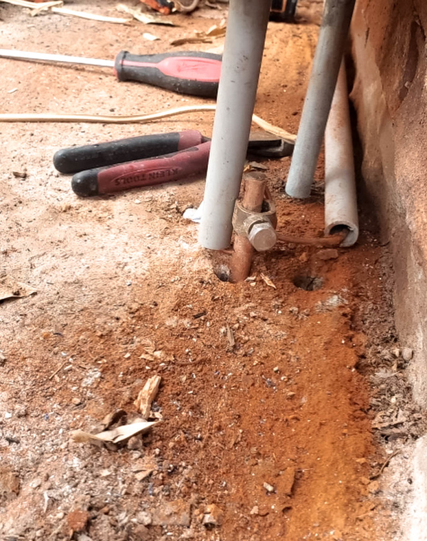 A close-up of an electrical grounding rod and conduits installed in the ground by Eon Electric in Orem, UT.