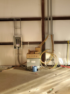 Electrical installation in progress with panels, transformer, and wiring by Overton Power Solutions Electric in Hephzibah, GA