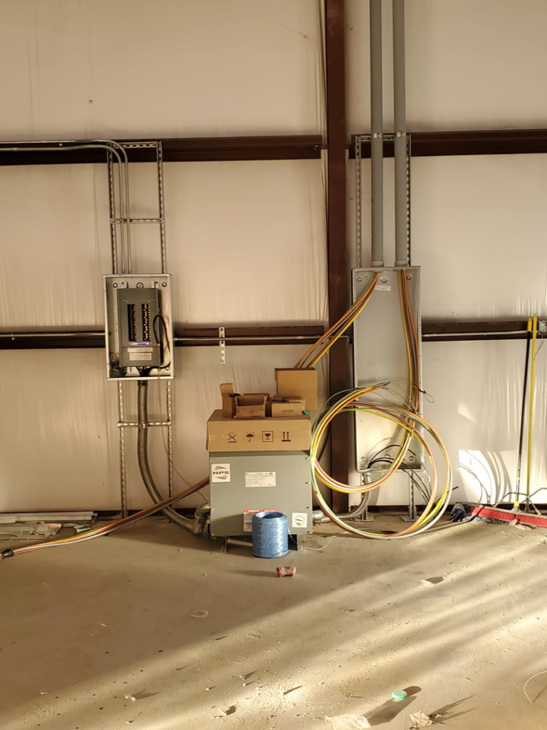 Electrical installation in progress with panels, transformer, and wiring by Overton Power Solutions Electric in Hephzibah, GA