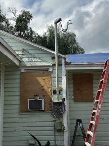 An electrical mast and meter on the exterior of a house, indicating electrical service work by Bee Electrical Contracting in Port Saint Lucie, FL.