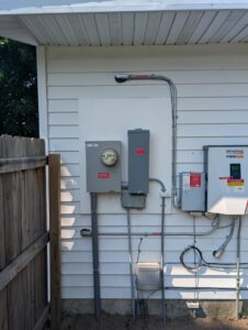 An electrical meter and Generac inverter installed on the side of a house by Cherry Valley Plumbing and Electrical in Middleville, MI