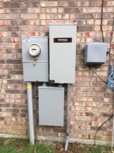 An electrical meter and transfer switch installation on a brick home by Optimize Generator People in Baton Rouge, LA.