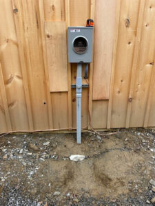 Electrical meter base and grounding wire installed on a wooden wall by Clemens Electric in Averill Park, NY