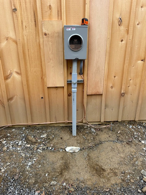 Electrical meter base and grounding wire installed on a wooden wall by Clemens Electric in Averill Park, NY