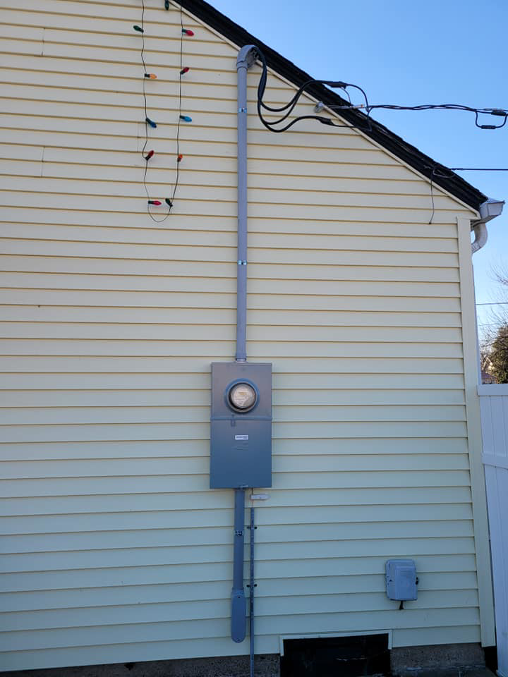 An electrical meter box and conduit installed on the side of a residential building by Benson Electric LLC in Owensboro, KY.
