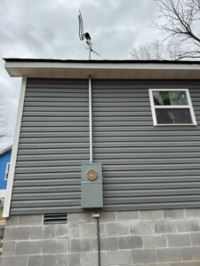 An exterior view of a new electrical meter box and conduit installation on a house by Stricklen Electrical Industries LLC in Clarksville, TN.