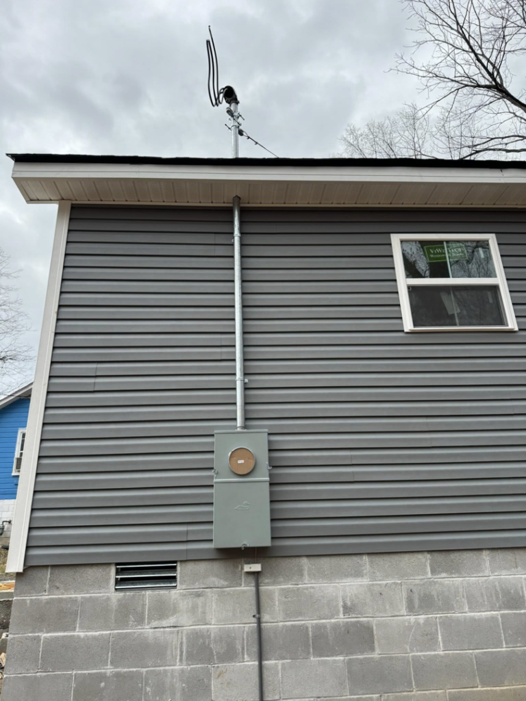 An exterior view of a new electrical meter box and conduit installation on a house by Stricklen Electrical Industries LLC in Clarksville, TN.