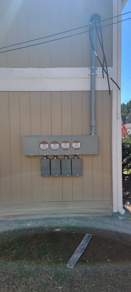 Exterior view of multiple electrical meters and conduit installed on a building by Trouble Shooters Electric Inc. in Pell City, AL