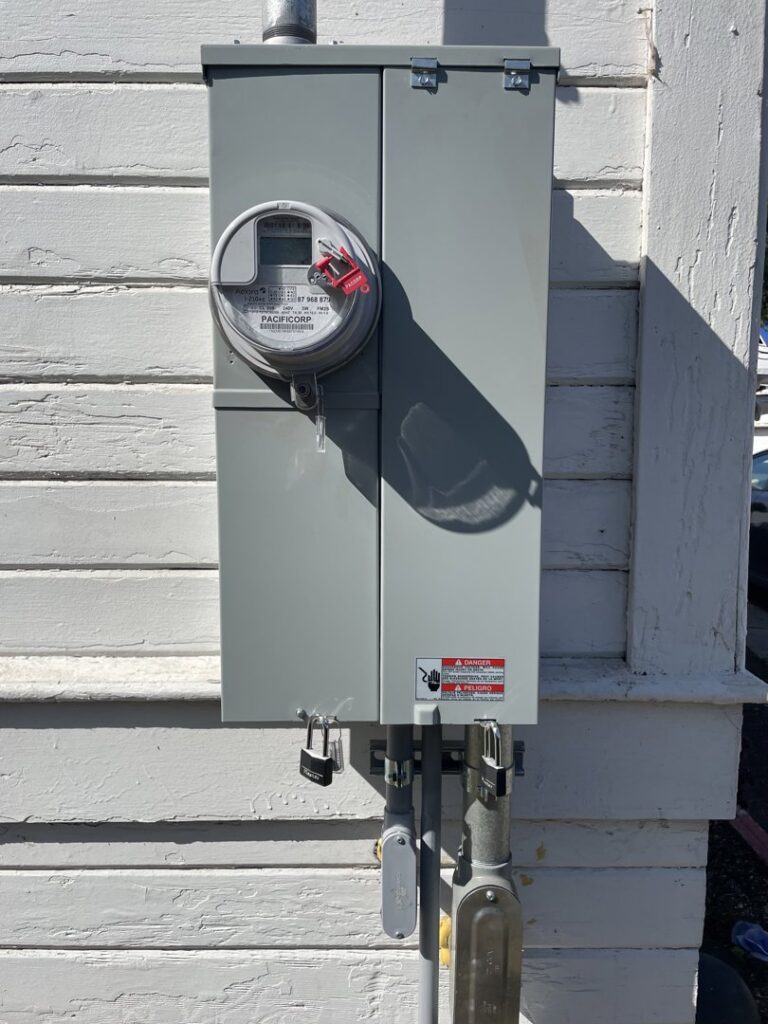 An outdoor electrical meter and main service panel installed on a building by Delatour Electric in Portland, OR.
