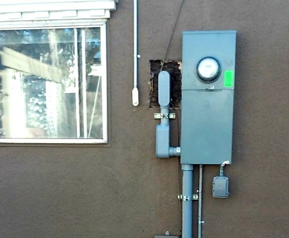 An electrical meter panel and conduit installed on the exterior of a building by Certified Electrician Albuquerque NM.