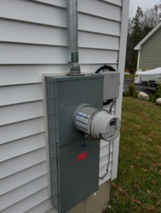 An installed electrical meter and service panel on the side of a house by IN Power Electric in Gorham, ME