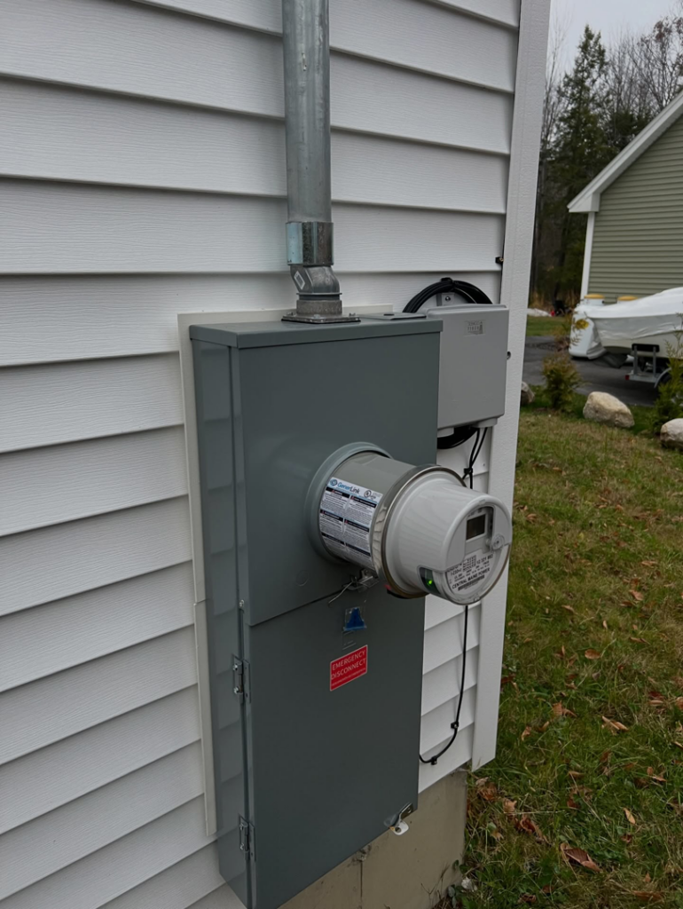 An installed electrical meter and service panel on the side of a house by IN Power Electric in Gorham, ME