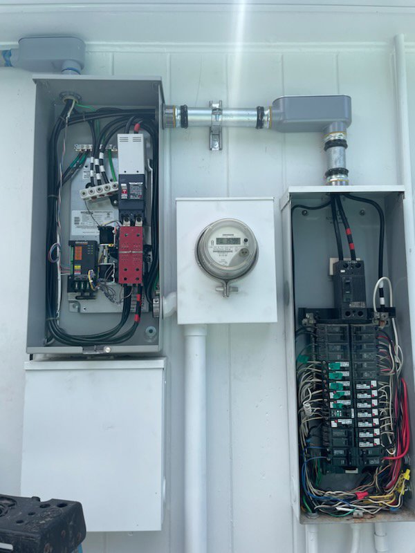 An electrical meter and open service panels displaying internal wiring and components, serviced by LOJ Electric, LLC in Houston, TX.