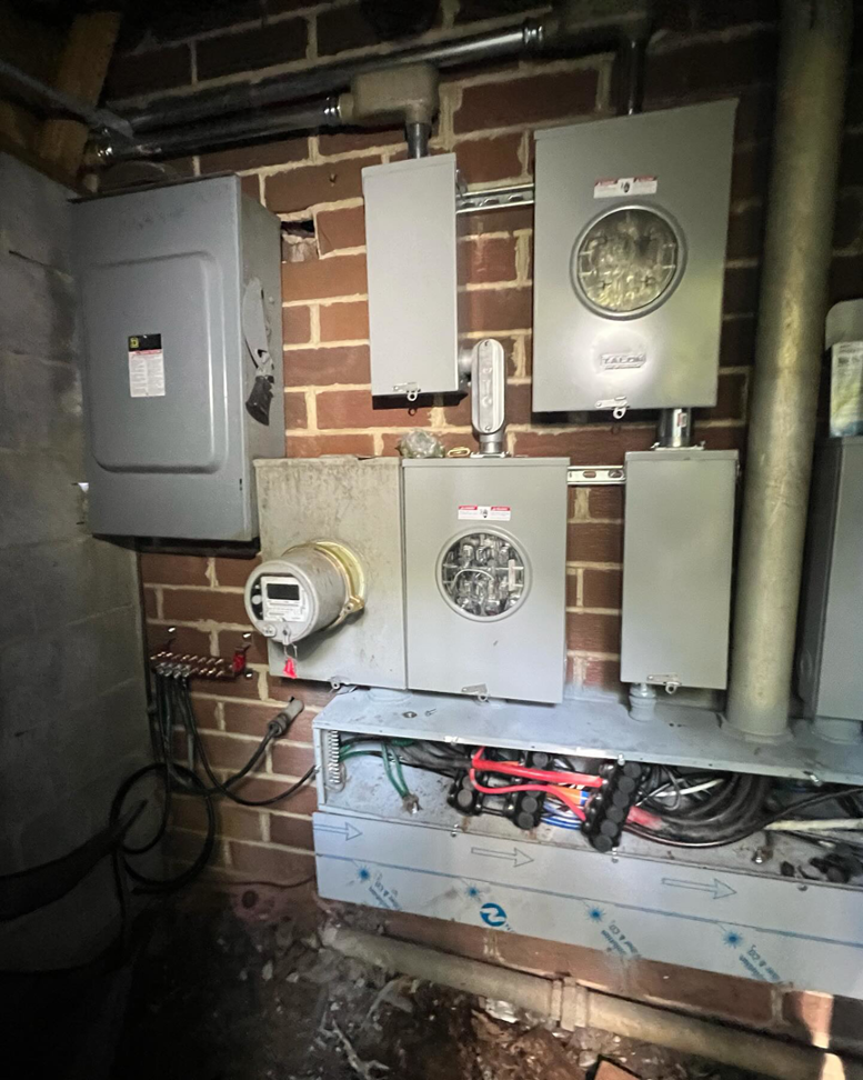 Multiple electrical meters and panels with an open section revealing internal wiring, installed by Sapphire Electric LLC in Jonesboro, GA.