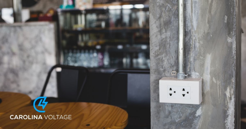 A newly installed electrical outlet on a concrete wall, showcasing electrical work by Carolina Voltage in Charlotte, NC.