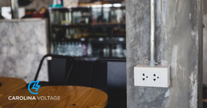 A newly installed electrical outlet on a concrete wall, showcasing electrical work by Carolina Voltage in Charlotte, NC.