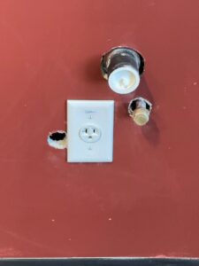 A newly installed electrical outlet on a red wall, showcasing electrical service by AC-DC Electric in Severance, CO.