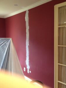 A wall showing electrical outlets and patching work, indicating recent electrical service by GEN3 Electric & HVAC in Philadelphia, PA.