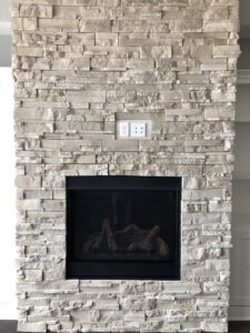 Electrical outlets installed above a stone fireplace by Sterling Electric in Fort Wayne, IN.
